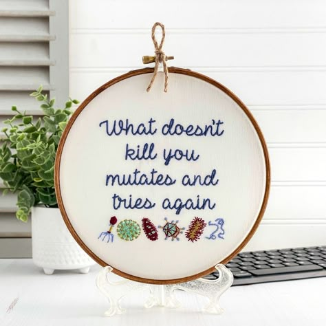 What doesn't kill you mutates and tries again. Finished and framed, this quirky embroidery hoop art is ready to hang or gift to the microbiologist in your life. Featuring detailed microbes(virus, bacteriophage, etc.) a scientist will appreciate the detailed stitching as well as a modern cool toned color palette of thread colors. This completed artwork is about 7 inches in diameter, so it works hung standalone on a wall or displayed on a shelf with other unique keepsakes. Free gift wrapping & a p Cool Toned Color Palette, Quirky Embroidery, Funny Embroidery, Nerd Crafts, Science Teacher Gifts, Funny Science, Nerdy Gifts, Framed Embroidery, Cross Stitch Finishing