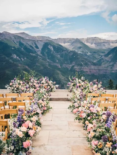 scenic outdoor wedding ceremony venue with mountain peaks in the distance and aisle lined with lush florals Nature, Wedding Flowers Down The Aisle, Spring Wedding Isles Decoration, Wedding Table Centerpiece Ideas, Spring Wedding Alter, Sunset Wedding Ceremony, Wedding Aisle Outdoor, Scenic Wedding, Wedding Flower Trends