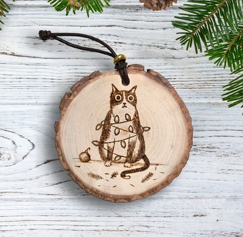 "Wood burned ornament by hand of a funny cat wrapped in Christmas lights. Approximately 2.75-3.25\" in diameter. I can add the date or other words to the back for an additional $2.00, just send me a message!" Christmas Ornament Wood Burning, Woodburn Christmas Ornaments, Wood Burning Art Christmas, Wood Burn Ornaments, Wood Burning Crafts Diy, Wood Burning Ornament, Wood Burned Christmas Ornaments, Animal Wood Burning, Woodburned Christmas Ornament