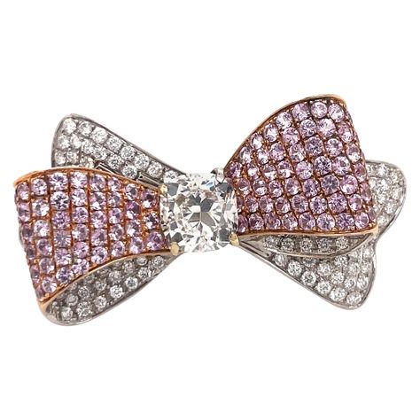 One fashionable Bow motif ring featuring a GIA Certified Cushion Brilliant weighng 3.01 Carats Color I Clarity VS1 flanked with pink Sapphires weighing 3.50 carats and round brilliants weighing 1.63 carats. GIA Certificate # 16357993 Jewelry Bow, Ribbon Ring, Diamond Bows, Bow Ring, Family Jewels, Bow Jewelry, Contemporary Ring, Diamond Brooch, Fine Jewelry Designers