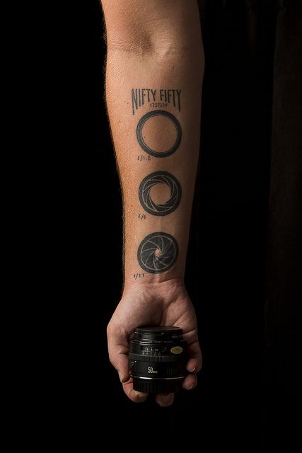 Does he realise this looks like the iris on a stargate? Lol. Camera Lense Tattoo, F Stop Tattoo, Tattoo Photography Ideas, Aperture Tattoo, Vintage Camera Tattoos, Camera Tattoo Design, Photography Tattoos, Photographer Tattoo, F Tattoo