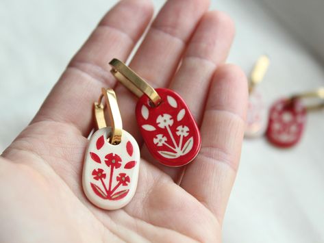 These charming double-sided ceramic earrings feature a striking combination of white and red hues. Handcrafted with meticulous care, they showcase an intricate floral pattern that adds a touch of ethnic elegance. Perfect as a thoughtful wedding jewelry gift, these earrings are designed to complement any bridal ensemble, making them a memorable and cherished addition to her special day. 🔸 Material and Technique Handmade white clay beads, coated with glaze and author's painting, accessories of 18K gold-plated brass. 🔸 Size The length of the earring with the post is 5 cm (1.97 inch) The size of the beads is from 2.9  (1.14 inch) The weight of the earrings is 12g 🔸 Gift box  https://www.etsy.com/listing/1613070823/wooden-jewelry-box-for-gifts-accessories?ref=listings_manager_grid 🔸 Recomme Sculpey Clay Jewelry, Clay Beaded Earrings, Baked Clay Earrings, Porcelain Earrings Ceramic Jewelry, Porcelain Jewelry Handmade, Red Polymer Clay Earrings, Ukrainian Earrings, Gifts For Managers, Diy Clay Jewelry