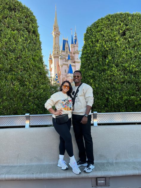 Couple in front of Disney castle in neutrals Disneyland Couple Outfits Winter, Disney Dad Outfits, Disney Mom Outfit Winter, Disney In November Outfits, Mom And Son Disney Outfits, Mom Disney Outfit Winter, Matching Disney Outfits Couples, Disney Outfits Couples, Disney Couple Outfits Ideas