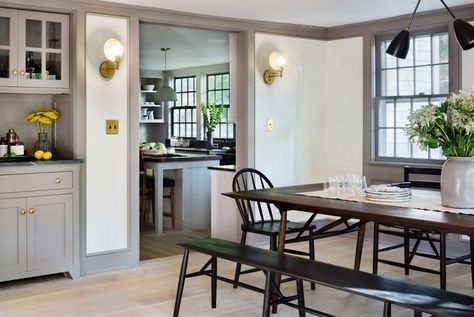 The warm gray paint that cloaks the trim on this farmhouse kitchen by Hendricks Churchill helps keep the even darker accents, like brass and black, from feeling stark against white walls | archdigest.com Black Dining Room Sets, Baseboard Styles, Millwork Wall, Farrow & Ball, Farmhouse Renovation, Gray Trim, Farmhouse Remodel, Small Farmhouse, Scandinavian Kitchen