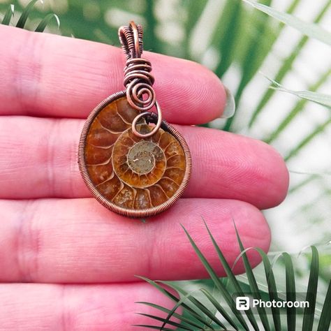 Shop autumnleaves713's closet or find the perfect look from millions of stylists. Fast shipping and buyer protection. Introducing the Copper Wire Wrap Ammonite Pendant! This exquisite pendant is a must-have for anyone who appreciates unique, handcrafted jewelry. Wrapped in high-quality copper wire using the ladder weave, this pendant is designed to showcase both the front and back of the beautiful fossil stone. But that's not all! Did you know that Ammonite is UV reactive? That's right, this st Wire Wrapped Ammonite, Copper Wire Wrapped Jewelry, Small Wire Wrapped Pendant, Ammonite Pendant, Ammonite Jewelry, Autumn Jewelry, Wrapping Jewelry, Unique Handcrafted Jewelry, Wire Jewelry Designs