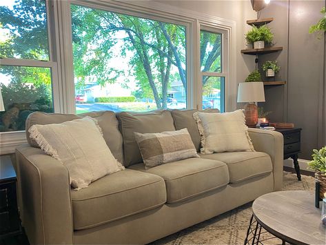 This 3 cushion sofa is the perfect fit in front of our picture window. With the addition of some cozy throw pillows, somw plants, and lighting, this becomes the perfect lounge space. #livingroomdecorideas #smalllivingroom #cozycouch #cozyspace #firsthome #neutralstyle #cottagecore Sectional Sofa Near Window, Couch In Front Of Window, Baywindow Sofa, Cozy Throw Pillows, Cozy Couch, Picture Windows, Cottage Core, Small Living Rooms, Small Living Room