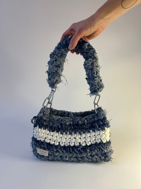 Up-cycled denim crochet bag in size M in light denim with white detailing. Sustainably handmade from up-cycled denim and 100% recycled yarn. Size: Length: 17 cm Width: 11 cm Height﻿: 15 cm Crochet Bags With T Shirt Yarn, Denim Yarn Projects, Denim Yarn Crochet, Yarn Bags Crochet, Denim Crochet Bag, Crochet On Denim, Crochet Repurpose, Crochet Bag Accessories, Handmade Bags Crochet