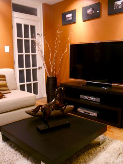 Black furniture and white trim provide contrast for this room's bold orange walls. Orange Living Room, Orange Rooms, Basement Living, Storage Inspiration, Living Room Orange, Living Room Color Schemes, Orange Walls, Room Paint Colors, Design Apartment