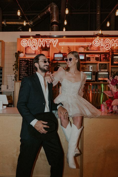 Direct flash photography trend at fun brewery elopement in downtown Calgary featuring pizza and cowboy boots. Short bridal dress sunglasses style. Neon sign elopement. Authentic elopement ideas. Vegas Cowboy Wedding, Short Wedding Dress With Cowboy Boots, Fun Short Wedding Dress, Retro Short Wedding Dress, Casual Wedding Photo Ideas, Fun Elopement Ideas, Engagement Photos Flash, Short Retro Wedding Dress, Fun Elopement Photos