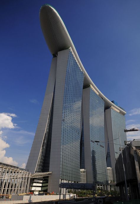 Marina Bay Sands in Singapore is an integrated resort with three 55-storey towers capped by a boat-shaped 340 meters long SkyPark with a 150 meters infinity swimming pool. This impressive resort developed by Las Vegas Sands and designed by Moshe Safdie Architects cost over US$6 billion to build. Singapore Architecture, Architectural Structure, Sands Singapore, Unusual Buildings, Famous Buildings, Interesting Buildings, Amazing Buildings, Unique Buildings, High Rise Building