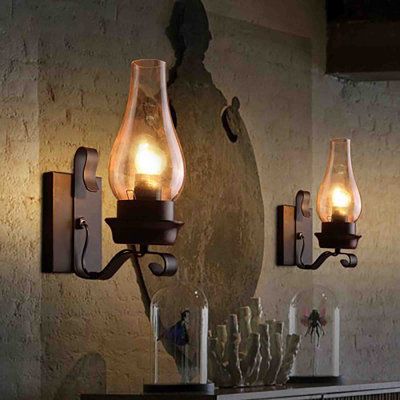 This vintage kerosene lamp shape/ chimney glass sconces design brings a vintage atmosphere to your home. Metal lamp body with matte black finishand and glass lampshade brings country style to your room. Longshore Tides | Longshore Tides Baurzhan Steel (Accents) Armed Sconce 11.8 H x 4.3 W x 7.9 D in black / brownGlass / Metal in Matte Black | 11.8" H X 4.3" W X 7.9" D | Wayfair Stairwell Sconces Lighting, Fireplace Sconces Lighting, Fireplace Sconces, Rustic Bathroom Light Fixtures Lowe's, Rustic Wall Sconces Lowe's, Rustic Candle Wall Sconces, Antler Wall Sconces, Primitive Candle Wall Sconces, Lantern Light Fixture