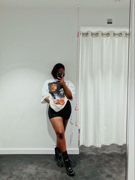 Black girl standing in front of mirror, posing in a white oversized space graphic kenzo t-shirt. Styled with black biker shorts and black dr martens boots. Biker Short And Graphic Tee Outfit, Oversized Shirt With Biker Shorts Outfit, Combat Boots And Shorts Outfit Black Women, Biker Shorts And Combat Boots, Graphic Tee And Shorts Black Women, Biker Shorts Boots Outfit, Dr Martens And Shorts Outfit, Shorts With Docs Outfits, Boots With Shorts Outfit Summer