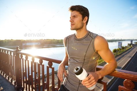 Sports man resting after running while leaning against bridge railing by vadymvdrobot. Concentrated young handsome sports man resting after running while leaning against bridge railing#running, #leaning, #bridge, #Sports Man Leaning On Railing, Leaning On A Railing Pose, Person Leaning On Railing, Leaning Against Railing Pose, Leaning On Railing Pose, Cinematic Reference, Leaning On Railing, Bridge Railing, Gesture Reference