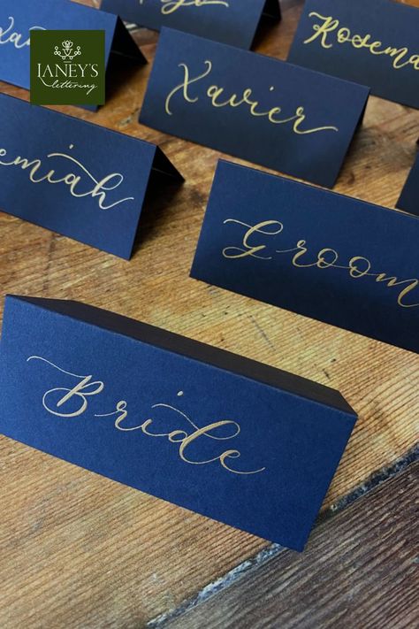 Navy Blue tent fold wedding place cards with Gold Calligraphy. Available to purchase in the online Etsy store, each place card is lettered by hand with wedding guest names #laneyslettering #placecards #tentfoldcards #tablescape #tablesetting #weddingcalligraphy #weddingideas #bluewedding #diywedding #placenames #escortcards #placesettings #weddingplanning Name Cards Table, Place Cards For Wedding, Calligraphy Place Cards, Place Setting Cards, Handwritten Wedding, Cards For Wedding, Wedding Place Names, Table Name Cards, Table Place Settings