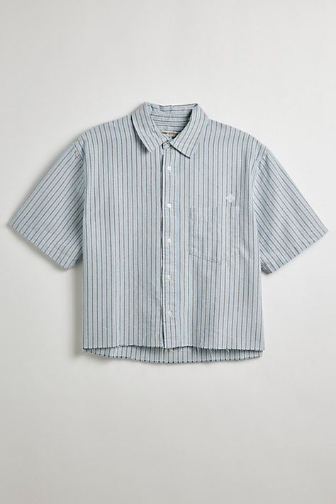 Updated stripe pattern Oxford shirt with a cropped hem. Short sleeve button-down shirt with a standard collar and left chest pocket. Features UO striped cut-off Oxford shirt Short sleeve shirt Standard collar Button-down front Chest pocket Boxy silhouette Cropped hem Content + Care 100% Cotton Machine wash Imported Size + Fit Model in Blue + Grey Stripe 6’2" and wearing size Medium Measurements taken from size Medium Chest: 24" Length: 23.5" | Urban Outfitters UO Striped Cut-Off Oxford Shirt Top Striped Button Up, Cropped Button Up, Cropped Shirt Men, Pastel Mens Fashion, Short Sleeve Button Up Men, Crop Top Men, Vintage Striped Shirt, Button Up Shirt Men, Mens Crop Top