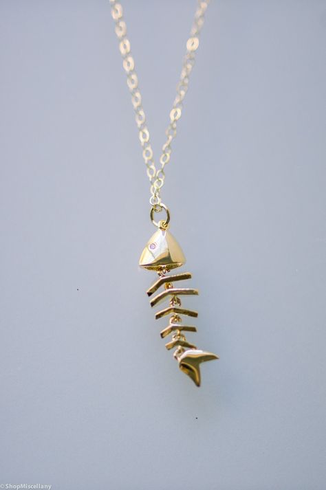 "M A T E R I A L S: - 14k gold filled chain and findings. - Gold plated skeleton fish pendant. - Pendant approximate measurements: 27.4mm x 8.2mm Please select your desired necklace length at the dropdown menu. Model wears a 18\" length. Don't see a length that you like? Just let me know upon check out. O P T I O N S: ♥ See more sterling silver and gold filled pieces here ♥ https://etsy.me/2PqZ7DY C A R E: - Please take special care by keeping all jewelry pieces from any type of liquid, perfume, Granada, Fishbone Necklace, Gifts For Fisherman, Fish Bone Necklace, Skeleton Necklace, Aesthetic Necklace, Fish Skeleton, Fantasy Earrings, Cool Piercings