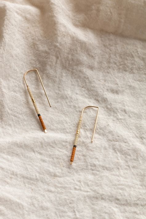 The 'Mala' Ear Pins (meaning 'To complete' in Tumbuka). Inspired by a balanced palette of earthen hues accented with charcoal and gold details, the sweet Mala Ear Pins are made from 14k gold-fill wire & Japanese glass beads, perfect for the everyday minimalist. Ear Pins, Skill Training, Mala Beads, Jewelry Inspo, Fashion Help, Gold Details, Wholesale Jewelry, The Sweet, Wire Jewelry