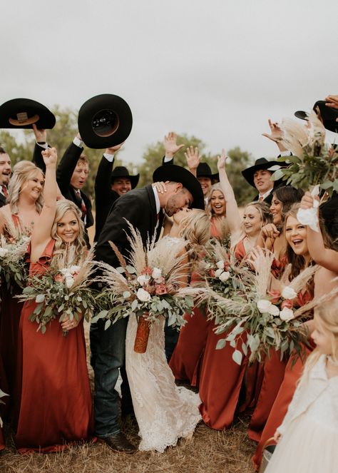 Western boho wedding party photo inspo - cowboy groomsmen and terracotta bridesmaid dresses from Azazie Fall Western Wedding Bridesmaid Dress, Wedding Party Photos Country, Western Wedding Couple Poses, Western September Wedding, Cowboy Bridesmaid Dresses, Western Bridesmaids Dresses, Western Wedding Party Photos, Bridesmaids With Cowboy Boots, Western Bridal Party Photos