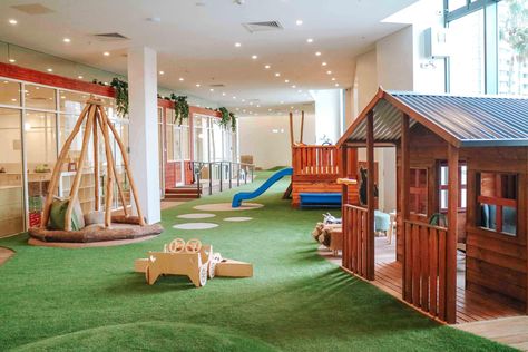 An indoor childcare playground with grass as the floor and a mini wooden house and slide. Preschool Montessori, Learning Preschool, House Slide, Montessori Playroom, Newcastle Nsw, Preschool Programs, Outdoor Play Area, Montessori Preschool, Early Learning Centre