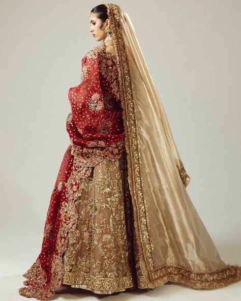 The dazzling gold organza lehenga choli, paired with a rich maroon dupatta, is a bridal ensemble fit for a queen. The dupatta's exquisite adda handwork shines with intricate red and gold mukesh and green bugle beads, expertly crafted to create a captivating contrast of colors and textures. This sumptuous outfit is a testament to the artisans' skill and attention to detail, making it a true masterpiece that exudes luxury and sophistication. For more details contact us on our WhatsApp +1 (908)... Golden Bridal Lehenga, Maroon Dupatta, Golden Lehenga, Gold Organza, Organza Lehenga, Latest Bridal Dresses, Pakistani Wedding Dress, Indian Bridal Hairstyles, Traditional Indian Outfits