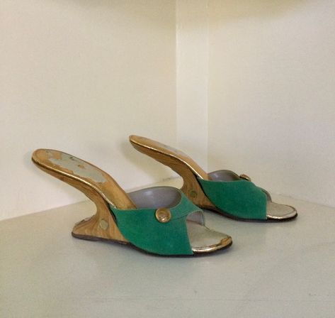 "Rare 1950s green suede boomerang mules with wooden heels.  Vamps are decorated with a golden button ornament and heels have golden disks running along the back curve and on the sides.  Size reads 7N but please refer to measurements below.  They probably fit more like a 6 1/2. Nice vintage condition.  One of the golden accents at the back of the heel is missing and the insoles have lost their shine in areas. This is not visible when worn as it's covered by your foot. There is a tiny notch in one Ball Heels, 90s Heels, Hippie Shoes, Wooden Heels, Gucci Heels, Vintage Heels, Unique Shoes, Wooden Heel, Green Suede