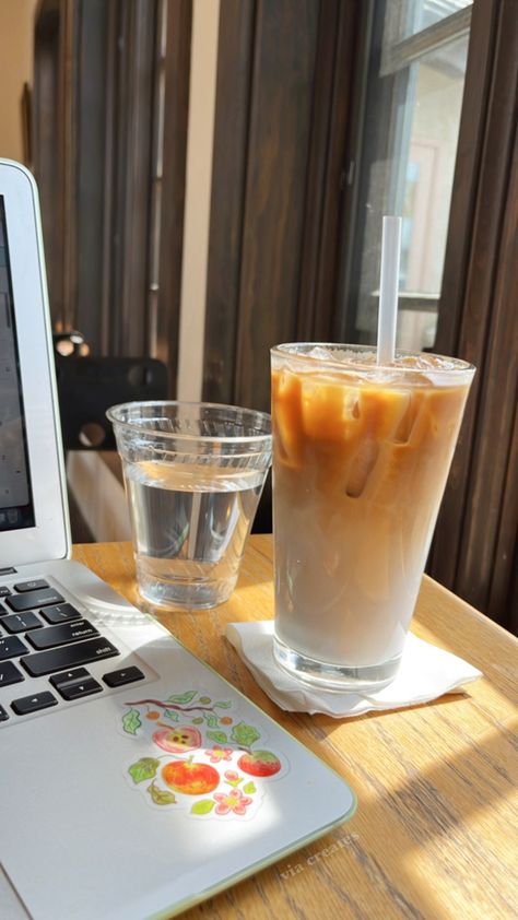 An iced latte, a cup of water, and a laptop sit on a cafe table next to a sunny window Blueberry Makeup, Blueberry Latte, Afternoon Vibes, Aesthetic Studying, Sunny Window, Cafe Aesthetic, Cafe Table, Afternoon Coffee, Coffee Shop Aesthetic