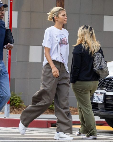 @Zendaya may be one of the biggest Gen Z stars in Hollywood, but the tried-and-true styling trick she was recently spotted in is borrowed straight from the millennial playbook. Tap the link in our bio for details. Zendaya Street Style, Zendaya Maree Stoermer Coleman, Zendaya Outfits, Zendaya Style, White Graphic Tee, Baggy Trousers, Zendaya Coleman, Black Slacks, Street Style Winter