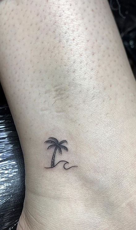 Palm Ankle Tattoo, Beach Tree Tattoo, Unique Palm Tree Tattoo, Tattoo Ideas Female Palm Tree, Palm Tree Water Tattoo, Palm Tree Wave Tattoo Ankle, Best Friend Palm Tree Tattoo, Small Tattoos For Beach Lovers, Small Tattoo Palm Tree