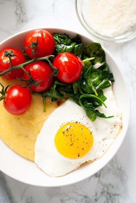 This savory polenta breakfast bowl is a nice switch up to morning outs. Creamy parmesan polenta is topped with sauteed tomatoes and spinach along with a fried egg in this comforting recipe. Vegetarian and gluten free! Savory Polenta, Polenta Breakfast, Breakfast Polenta, Parmesan Polenta, Sauteed Tomatoes, Clean Eating Vegetarian Recipes, Clean Eating Vegetarian, Gluten Free Dishes, Recipe Vegetarian