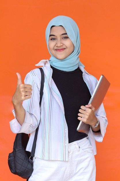 Photo asian muslim student hold pc lapto... | Premium Photo #Freepik #photo #asian-laptop #asian-student #asian-study #online-student College Student Photo, Student Pic, Student Photo, Thumb Up, Photography Student, Books Cover, Church Poster Design, Church Poster, Online Student