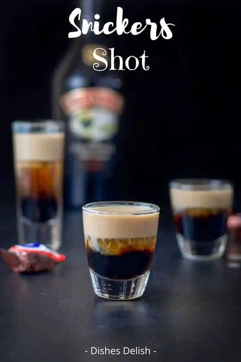 This Snickers shot has only three ingredients: Kahlúa, Frangelico and Baileys Irish cream! So delicious and reminiscent of the famous candy bar! #snickersshot #layeredshot #dishesdelish Candy Bar Shots, Irish Shots Drinks, Shots With Baileys Irish Cream, Drinks With Baileys And Kahlua, Baileys And Vodka Drinks, Baileys And Kahlua Drinks, Irish Cream Shots, Nye Shots, Baileys Recipes Drinks Cocktails