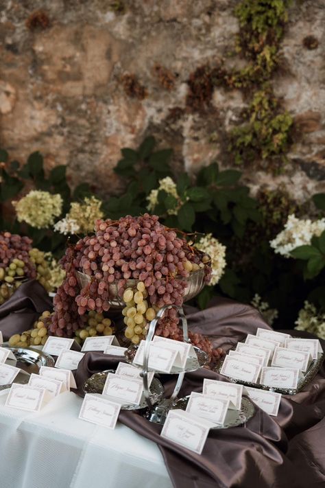 Escort card table, vintage oppulence Italian style, grapes and silver platters. Completely unique. Styled by Wiskow & White Fruit Seating Chart, Grapes Centerpiece Wedding, Dark Italian Wedding, Italian Wedding Design, Grape Theme Party, Italian Wedding Cocktail Hour, Italian Vintage Wedding, Italian Style Wedding Decorations, Old Italian Wedding