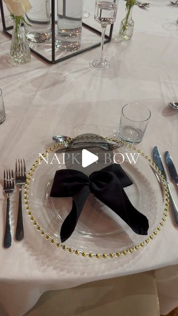 Wedding & Event Stylists on Instagram: "BOWS 🎀🖤 Hair bows, and now NAPKIN bows ✨ how pretty and just stylish!! Here’s a HOW TO for you! 🖤 #weddinginspiration #weddinginspiration #weddingstyle #weddingstyling #napkinfolding #napkins #napkinbow #bowseason #bows #weddingtabledecor #weddingtablescape #weddingcenterpieces" Napkin Bow Tie, Bows In Wedding Decor, Bowtie Napkin Fold, Napkin Designs For Weddings, Different Napkin Folds Wedding, Now Napkin Fold, How To Fold Cheesecloth Napkin, Cute Napkin Folds Easy, Bow Wedding Table Decor