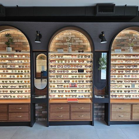 These photos showcase a one-of-a-kind Optometry store in downtown Toronto, where we had the opportunity to create custom millwork. This practice stands out from the competition with its unique retail area, featuring Matte Black archways, Walnut drawers, glass shelves, and LED lighting against a brick backdrop. All aspects of this Millwork were custom built as per the designers vision. Optometrists and General Contractors seeking custom millwork for their projects can contact Ontario Wood ... Luxury Optical Store, Optical Office Design, Opticals Showroom, Optical Boutique, Optical Office, Eyewear Shop Design, Brick Backdrop, Optometrist Office, Optometry Office