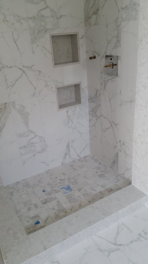 Using the same marble tile on the shower walls and the bathroom floor ties the entire design together. Engineered Marble Showers, 12x24 Marble Tile Bathroom, Faux Marble Tile Shower Walls, Marble Look Porcelain Tile Bathroom Shower Walls, Porcelain Marble Tile Bathroom, 12x24 Tile Patterns Shower Walls, Marble Tile Shower Walls, Porcelain Tile Shower Walls, Porcelain Shower Walls