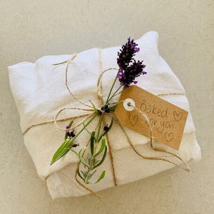 how to gift wrap sourdough in beautiful linen tea towels Artisan Bread Wrapping Ideas, Gifting Bread Wrap Packaging, Wrapping Bread For Gifts Packaging Ideas, Wrapped Bread For Gifts, Wrapped Sourdough Bread, Artisan Bread Gift Packaging, How To Wrap Bread With Tea Towel, Wrapping Homemade Bread Gift Ideas, Sourdough Starter Christmas Gift