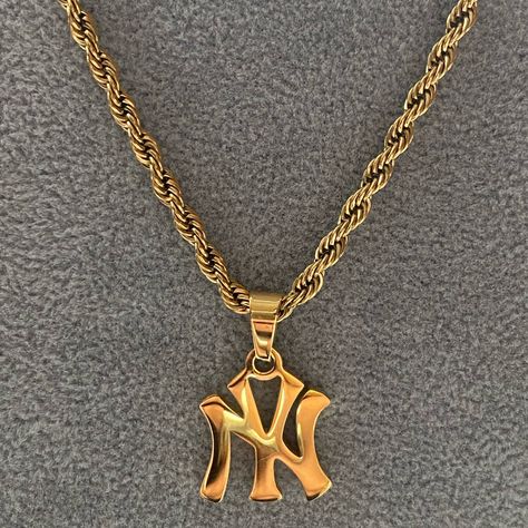 A classic New York pendant design featuring a 3mm luxe rope chain.  Shower, workout or swim - this chain does not tarnish.  Materials: 18K Gold Plated / Stainless Steel Chain Length: 45cm or 50cm Chain Thickness: 3 mm Hypoallergenic / Tarnish-Free Gold Men Jewelry, Yankee Necklace, 90s Gold Jewelry, Yankees Necklace, Gold Jewelry Men, Jewelry Street Style, Ny Necklace, Shower Workout, Gold Necklace Stack