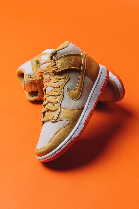 This take on the Dunk High sees the silhouette's classic leather base swapped with a course, tan-coated canvas material. The neutral upper is covered in shades of wheat and gold and create a scheme that's effortless to style, all atop a bright orange outsole that adds some pop underfoot.⁠ Shop now online. Basketball Shoe Photography, Nike Shoe Photography, Shoe Photography Ideas, Product Photography Shoes, Shoe Product Photography, Shoes Product Photography, Shoes Photography Ideas, Nike Air Presto Black, Sneaker Photography