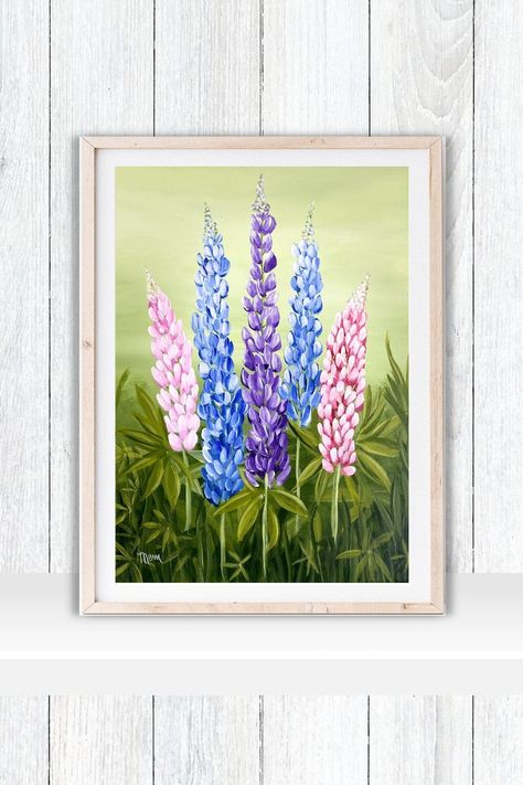 A framed acrylic painting print of 5 lupines.  Lupines are pink blue and purple on a light green background with vibrant green leaves and grasses at the base.  The print is framed in a light wooden frame with a white mat.  The frame sits on a white shelf against a white wall. Lupine Painting, Colourful Wall Decor, Lupine Flowers, Easy Canvas, Easy Canvas Painting, Floral Prints Art, Flower Prints Art, Floral Wall Art, Nova Scotia