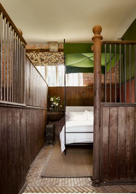 A corner manger has been converted into a slate-topped bedside table in this ground floor bedroom, which has its bathroom in an adjacent loosebox. The blind is in ‘Kashida’ by Zoffany – a crewelwork design in wool on heavy cotton, used in several of the bedrooms, and the iron four-poster is by Francis Russell. Dark Purple Walls, Stable Conversion, Chalet Design, St Giles, House Restoration, Equestrian Decor, Farm Buildings, Barn Conversion, Large Dining Room