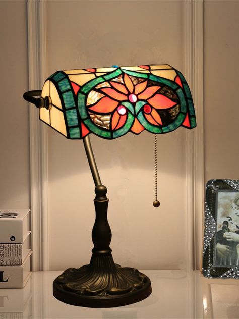 Feature 
 This Tiffany Lamp is a timeless and classic table lamp. The base is made from a durable metal, finished in a beautiful warm bronze tone that exudes vintage chic. The glass lampshade is an exquisite mosaic of stained glass pieces each hand-crafted and designed to create a stunning effect when illuminated. This delicate retro lamp is perfect for setting the mood in your living room. The gentle light creates a cozy and inviting atmosphere, perfect for any decor style. Tiffany Lamps Living Room Decor, Stain Glass Lamp, Cozy Lamps, Stained Glass Lampshade, Stained Glass Lamp, Classic Table Lamp, Tiffany Table Lamps, Tiffany Lamp, Deco Salon