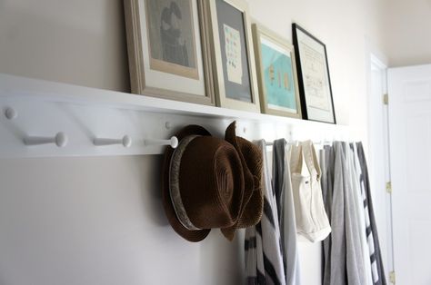 White Shaker Peg Rail with shelf in hallway, straw hats and towels, framed artwork | Remodelista Organisation, Peg Rails, Shaker Peg Rail, Peg Rail, Coat Pegs, Shaker Pegs, Hallway Storage, Object Lessons, Wooden Pegs