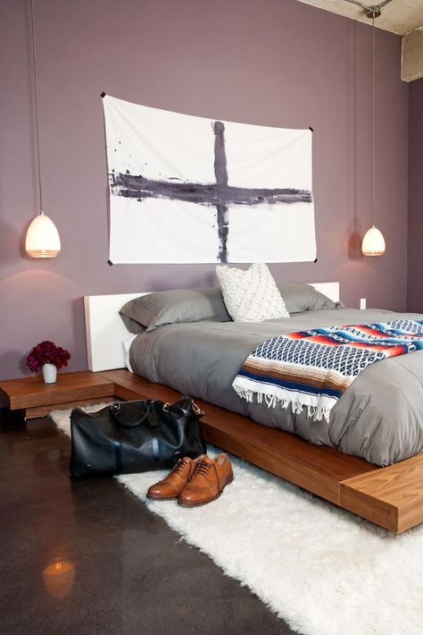 This modern master bedroom features light purple walls, a platform bed and bedside pendant lights. Minimalist artwork, gray bedding and dark wood tones create a subtle masculine vibe in the space. Light Purple Walls, Bedroom Masculine, Bachelor Bedroom, Small Bedroom Remodel, Masculine Bedroom, Modern Minimalist Bedroom, Purple Bedroom, Minimalist Bedroom Design, Purple Walls