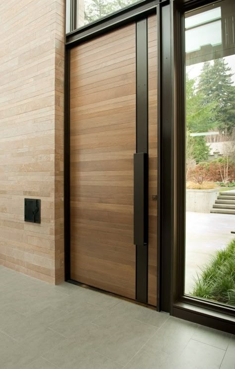 Architect: Stuart Silk Architects   Let’s start with a modern take on a classic. Smooth horizontal wood panels gain a contemporary update with a silky black handle guard that runs from top to bottom. Pintu Interior, Modern Entrance, Modern Front Door, Entrance Door Design, Wooden Front Doors, Door Inspiration, Front Door Entrance, Door Design Modern, Door Design Interior