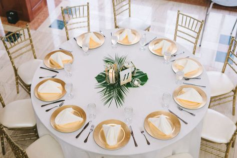 Modern Classic Tropical Wedding Reception Decor, Round Tables with White Linens, Gold Chiavari Chairs, Gold Chargers, Monstera Palm Tree Leaf Centerpiece and Geometric Candle Holders | Wedding Photographer Kera Photography | St. Pete Wedding Venue The Poynter Institute Tropical Wedding Reception Decor, Leaf Centerpiece, Tropical Wedding Centerpieces, Tropical Wedding Reception, Tropical Centerpieces, Geometric Candle, St Pete Wedding, Tropical Wedding Theme, Tropical Wedding Decor