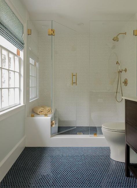 Navy penny floor tiles lead to a walk-in frameless glass shower accented with a brass handle. Gömda Rum, Penny Tiles Bathroom, Blue Bathroom Tile, Penny Tile, Shower Floor Tile, Floor Bathroom, Cottage Bathroom, Transitional Bathroom, Master Bath Remodel