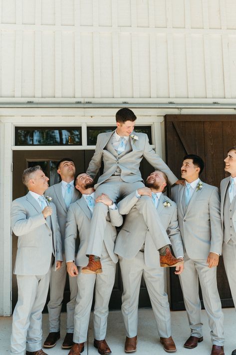 The bridal party complemented the elegant white barn wedding theme and cream, ivory & blue wedding color palette. Bridesmaids wore powder blue dresses with the groomsmen in light grey suits, pale blue ties and brown shoes. See all the magical moments from this rustic, farmhouse style wedding. Check out these groomsmen photo ideas. Captured by Infinite Film + Photo, Atlanta Wedding Photographer. Blue Gray Groomsmen Suits, Blue Wedding Theme Suits, Smoky Blue Wedding Theme, Grey Suits With Blue Ties, Light Grey Groomsmen Attire, Black Tux With Dusty Blue, Sky Blue Bridesmaids And Groomsmen, Dusty Blue Gray Wedding, Wedding Color Light Blue