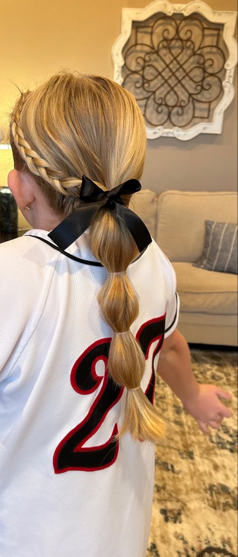 Softball Ribbon Hairstyles, Cheerleading Updos Cheer Hair, Hair For Tball Pictures, Toddler Girl Tball Hair, Girls Baseball Hairstyles, Softball Hair With Ribbon, Quick And Easy Softball Hairstyles, T Ball Hairstyles Kids, Softball Hairstyles For Picture Day