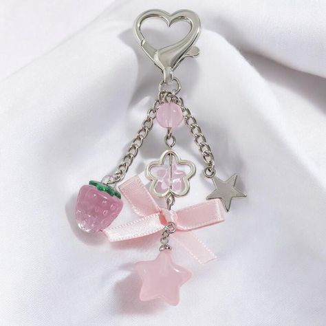 Elevate your accessory game with our Cute Pink Strawberry Bow Keychain! This charming keychain blends playful design with a touch of nostalgia, perfect for women and girls who adore the Y2K aesthetic. The eye-catching pink strawberry bow serves as the focal point, bringing a sweet and whimsical vibe to any ensemble. The keychain features an intricate star flower tassel that adds a touch of sparkle and movement, along with a heart-shaped charm that symbolizes love and affection. Each element is m Pink Keychain, Heart And Key, Heart Keychain, Jewelry Accessories Ideas, Star Flower, Everyday Items, Delicate Details, Cute Pink, Playful Design