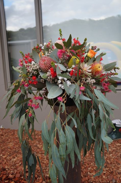 Large arrangement of banksias, gum leaves, tetragona, tea tree, flowering gum and orange roses in a rustic chimney flu. By RANE flowers Native American Floral Arrangements, Gum Leaves Table Decorations, Large Native Flower Arrangements, Australian Native Wedding Table Flower Arrangements, Australian Flower Bouquet, Native Floral Arrangements, Australian Native Wedding Flowers, Native Flower Arrangements, Rustic Chimney